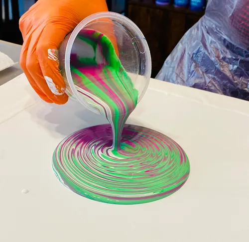 Colorful paint poured onto canvas swirl.