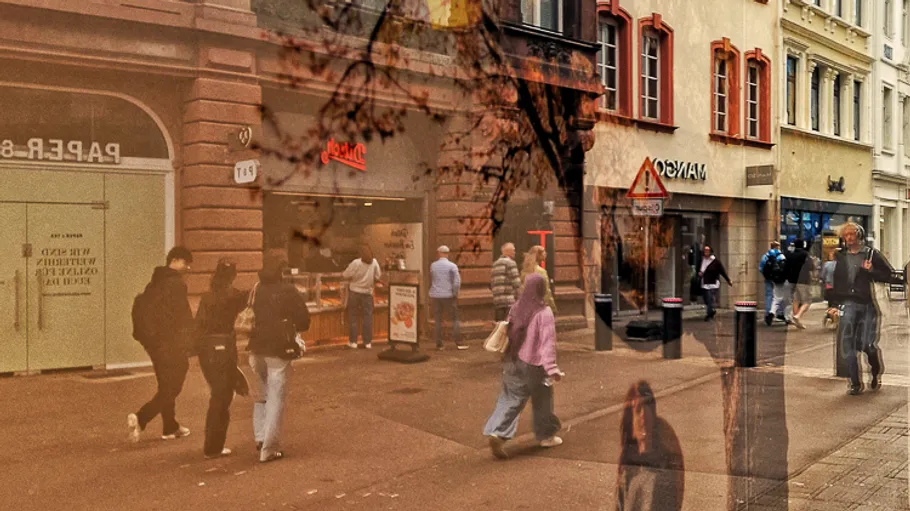 Menschen gehen auf einer belebten Straße mit Läden.