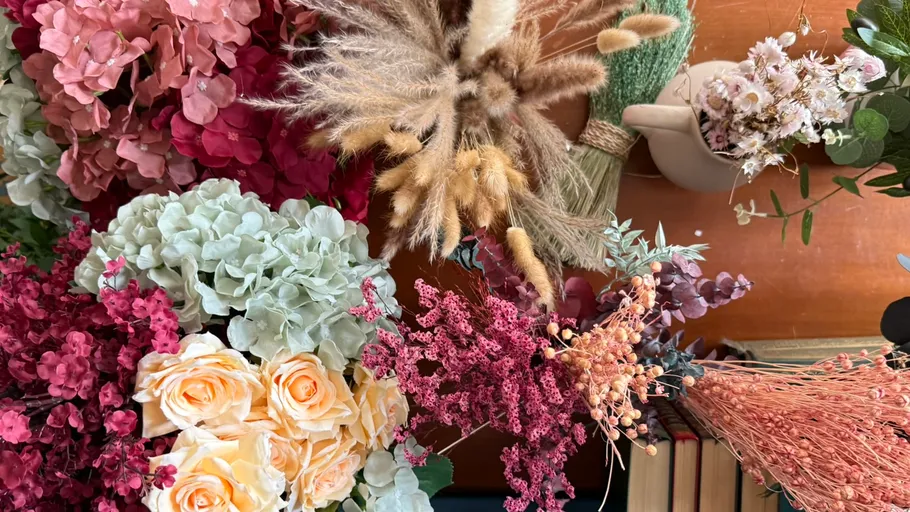 Verschiedene bunte Blumen und Pflanzen auf Tisch.