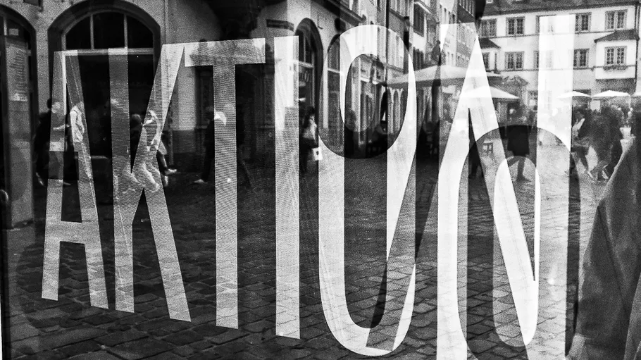 Shop window reflection with people walking outside.