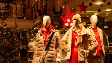 Drei Schaufensterpuppen tragen Winterkleidung im Laden.
