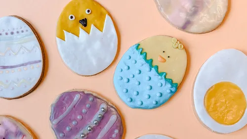 Decorated Easter cookies on a peach background.