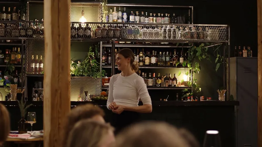 Frau lächelt in stilvoller Barumgebung.