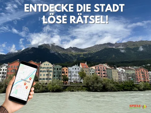 Hand holding phone, colorful buildings, mountains.