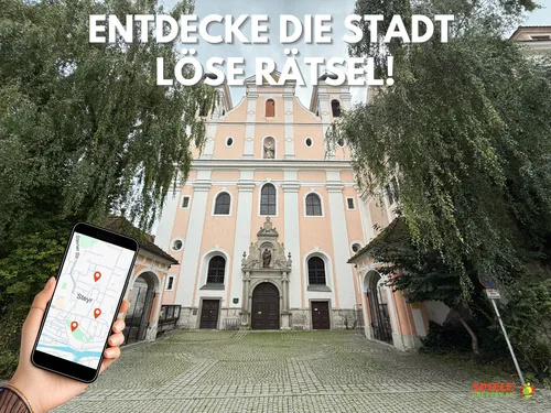 Hand hält Smartphone mit Karte, vor Kirche.