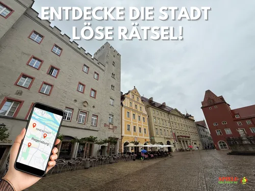 Hand hält Handy mit Regensburg-Karte, Stadt im Hintergrund.
