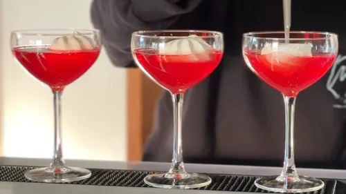 Three red cocktails with large ice cubes.