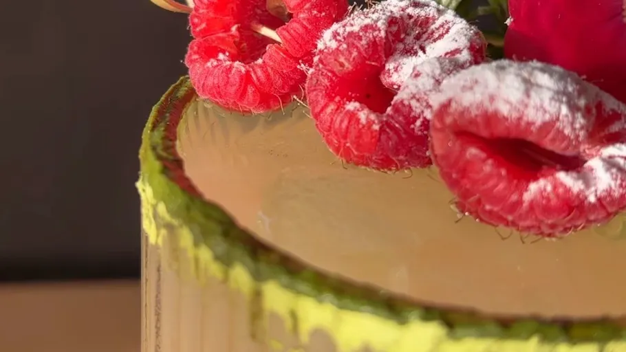 Cake with raspberries and powdered sugar topping.