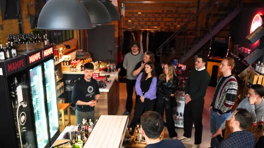 People listening to bartender in cozy bar.