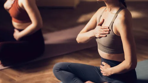 Two women practicing yoga in a studio.