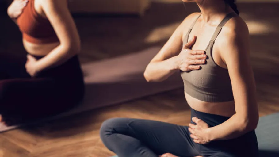 Two women practicing yoga in a studio.
