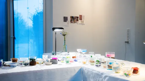 Colorful beads displayed on white table, indoor setting.