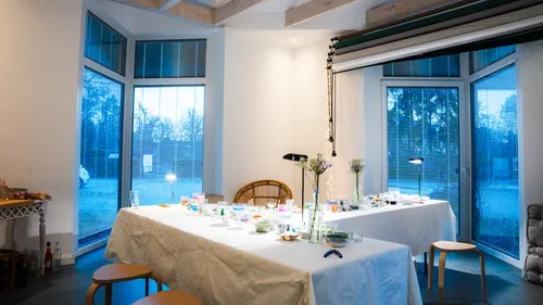 Dekorierter Tisch in modernem Raum mit großen Fenstern.