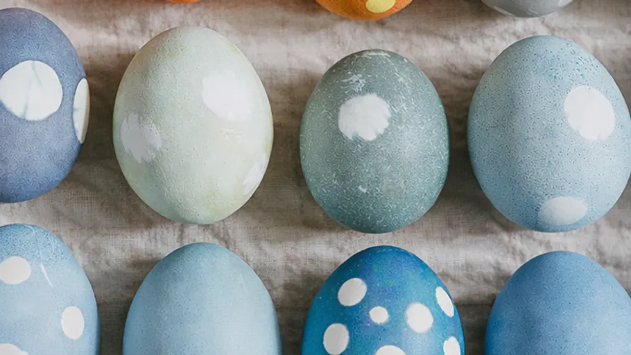 Colorful patterned eggs on a cloth surface.