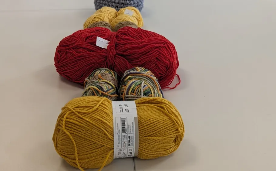 Balls of yarn lined up on table.
