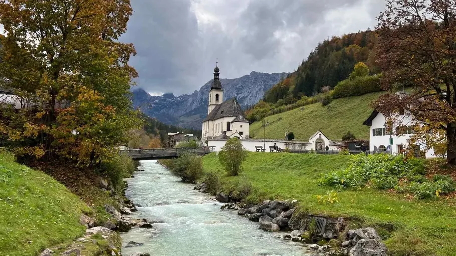 Church near river in mountainous landscape.