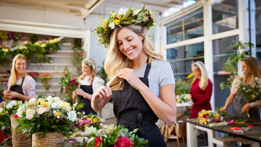Women making flower arrangements in workshop.