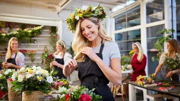 Frauen erstellen Blumenarrangements im Workshop.