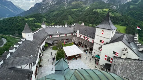 Medieval castle courtyard with mountain backdrop.