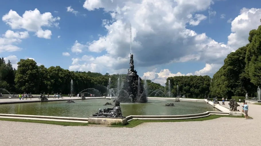 Large fountain with statues in a park.
