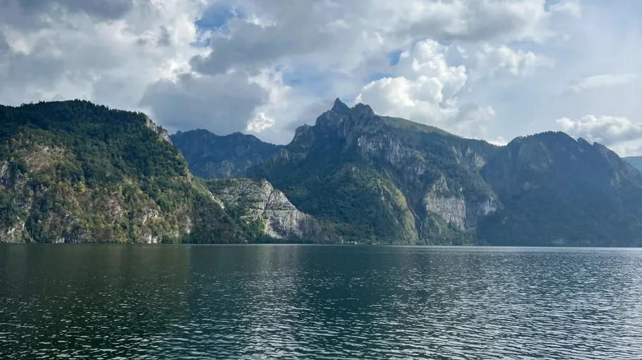 Mountain landscape with lake under cloudy sky.