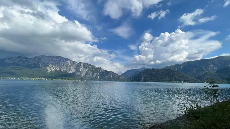 Lake reflecting mountains and cloudy sky.