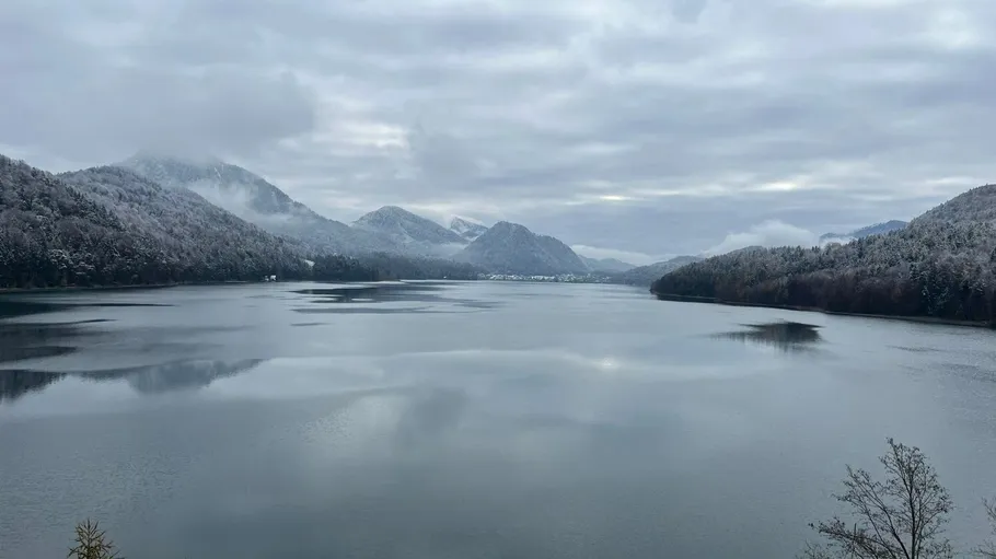Snowy mountains reflected in calm lake.