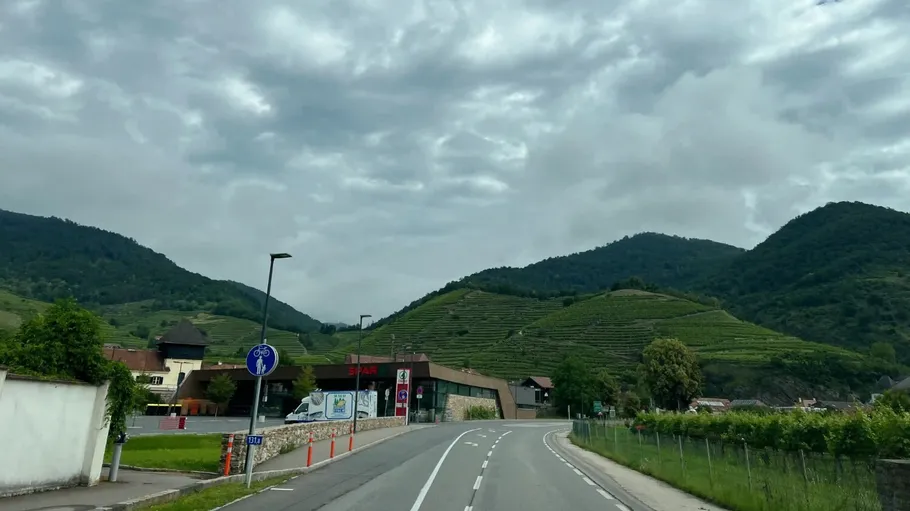 Straße biegt sich neben Weinbergen und Hügeln.
