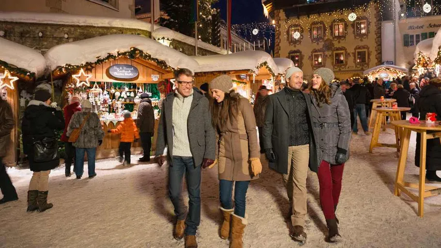 Gruppe spaziert auf festlichem Weihnachtsmarkt.
