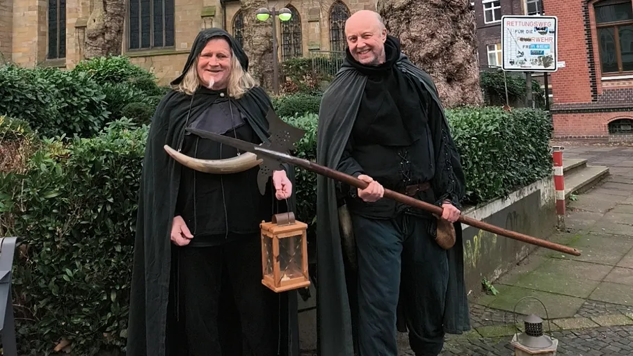 Zwei Personen in mittelalterlichen Kostümen mit Laternen.