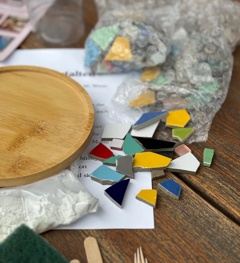 Bunte Mosaikfliesen auf Holztisch.