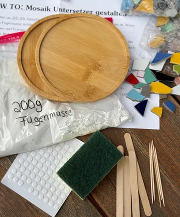Mosaic kit with tiles and tools on table.