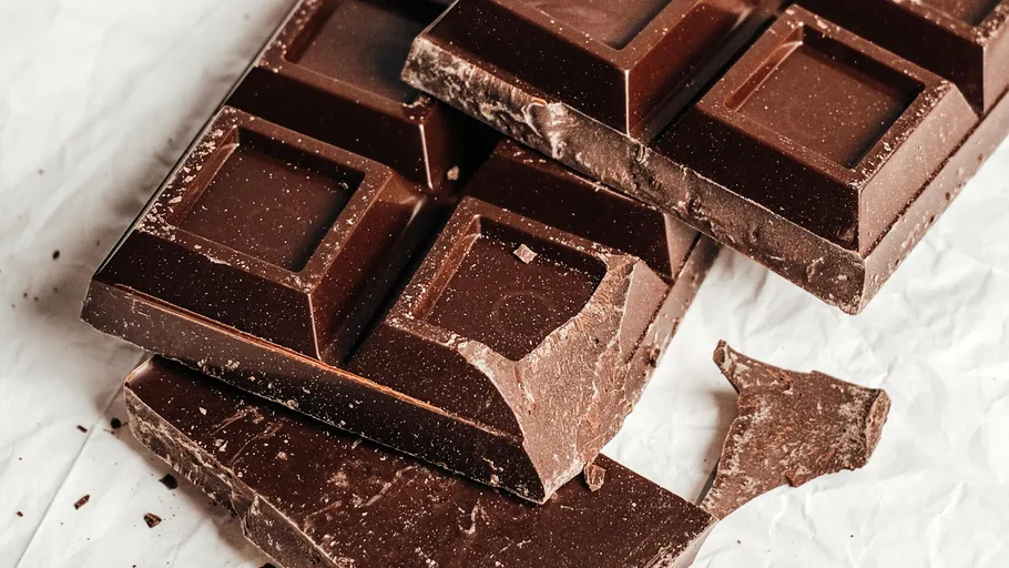 Dunkle Schokoladentafeln auf Papier zerbrochen.