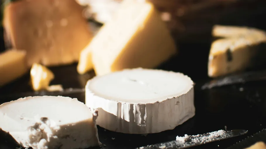 Assorted cheeses on a dark surface.
