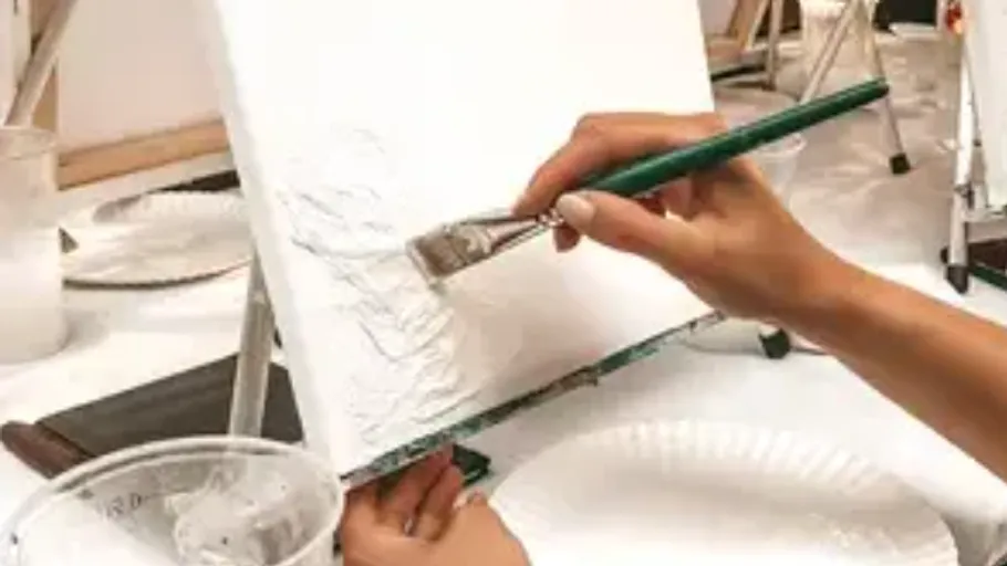 Person painting on canvas in studio.