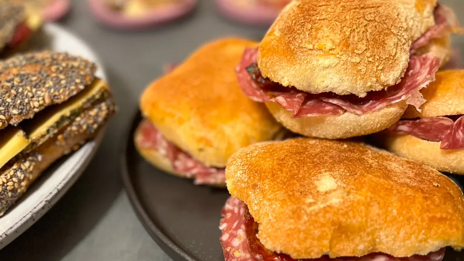 Sandwiches mit Salami auf zwei Tellern.