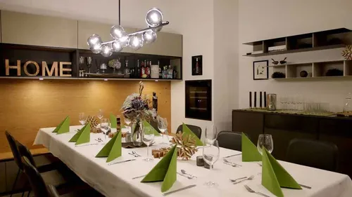 Dining table with folded green napkins, modern decor.
