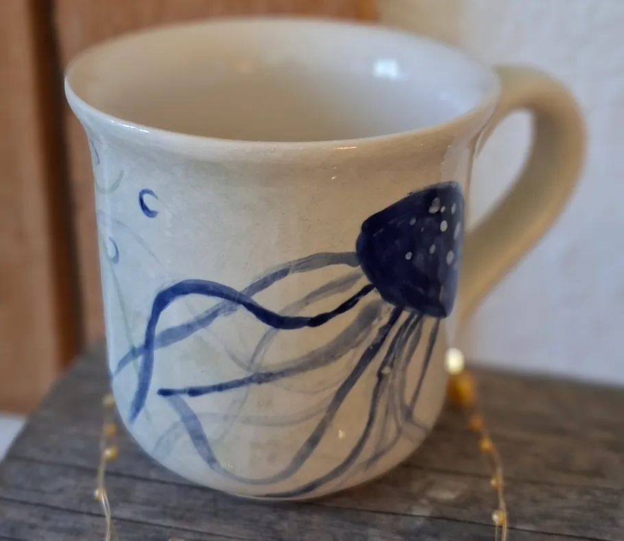 Keramiktasse mit blauem Quallen-Design.