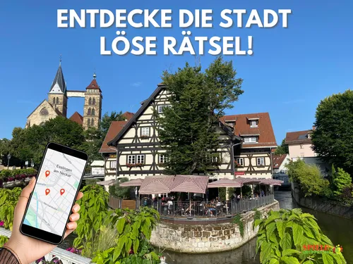 Hand holding phone in front of German town.