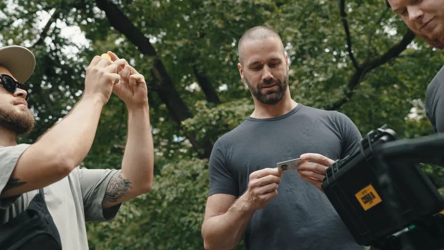 Three men examining identification outdoors.