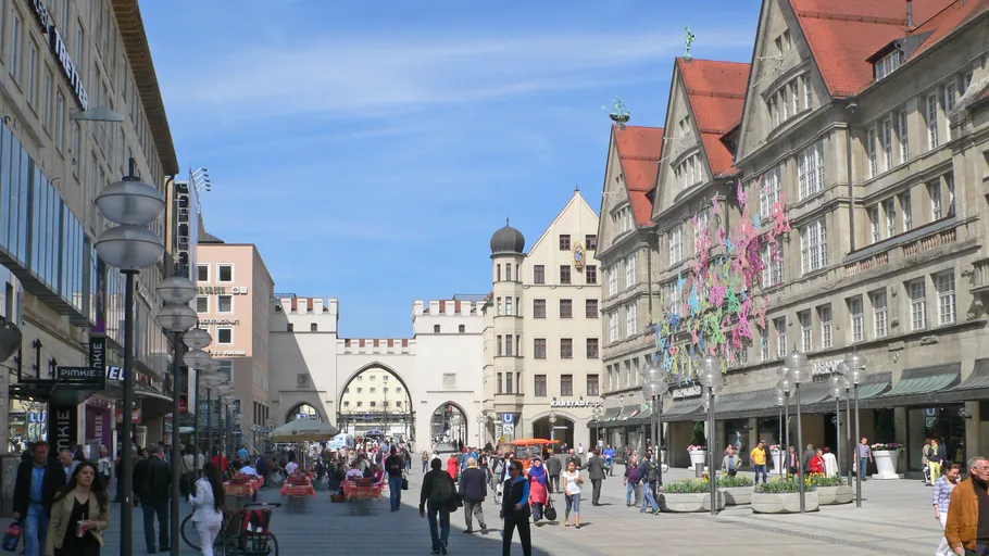 Menschen gehen auf Straße mit historischen Gebäuden.