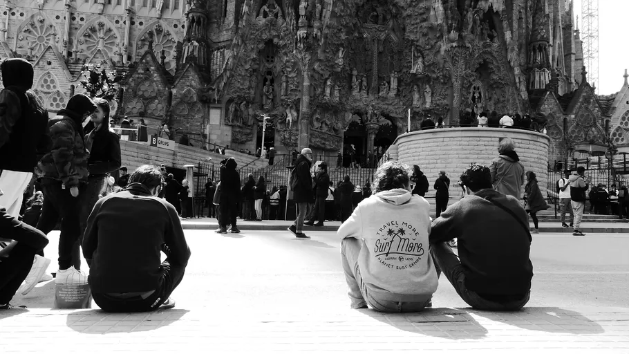 Three people sitting in front of ornate building.
