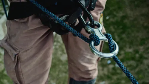 Close-up of climbing harness with rope outdoors.