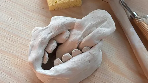 Clay sculpture of a mouth on a table.
