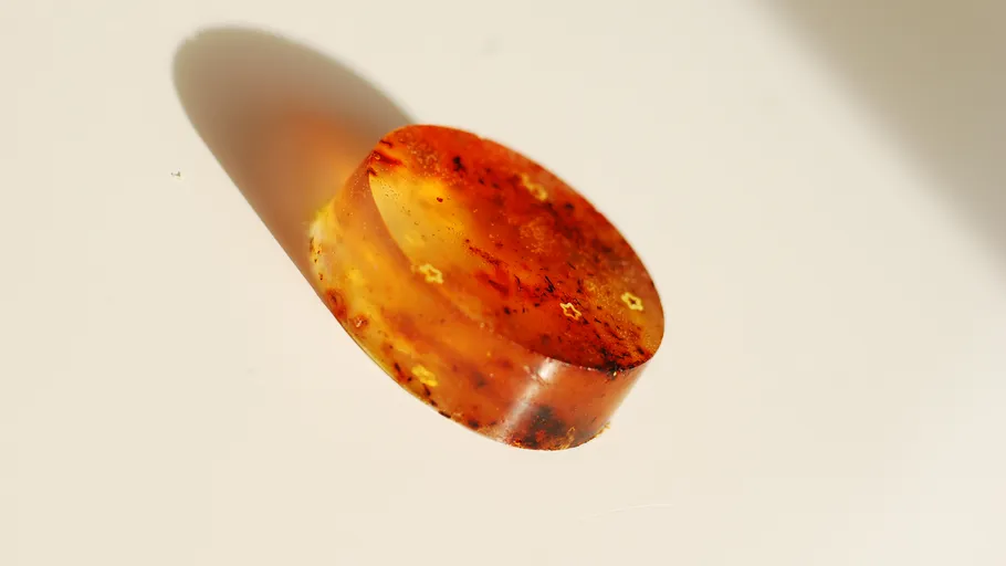 Translucent amber disk on white surface.