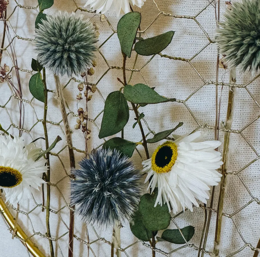 Getrocknete Blumen und Blätter auf Drahtdekor.