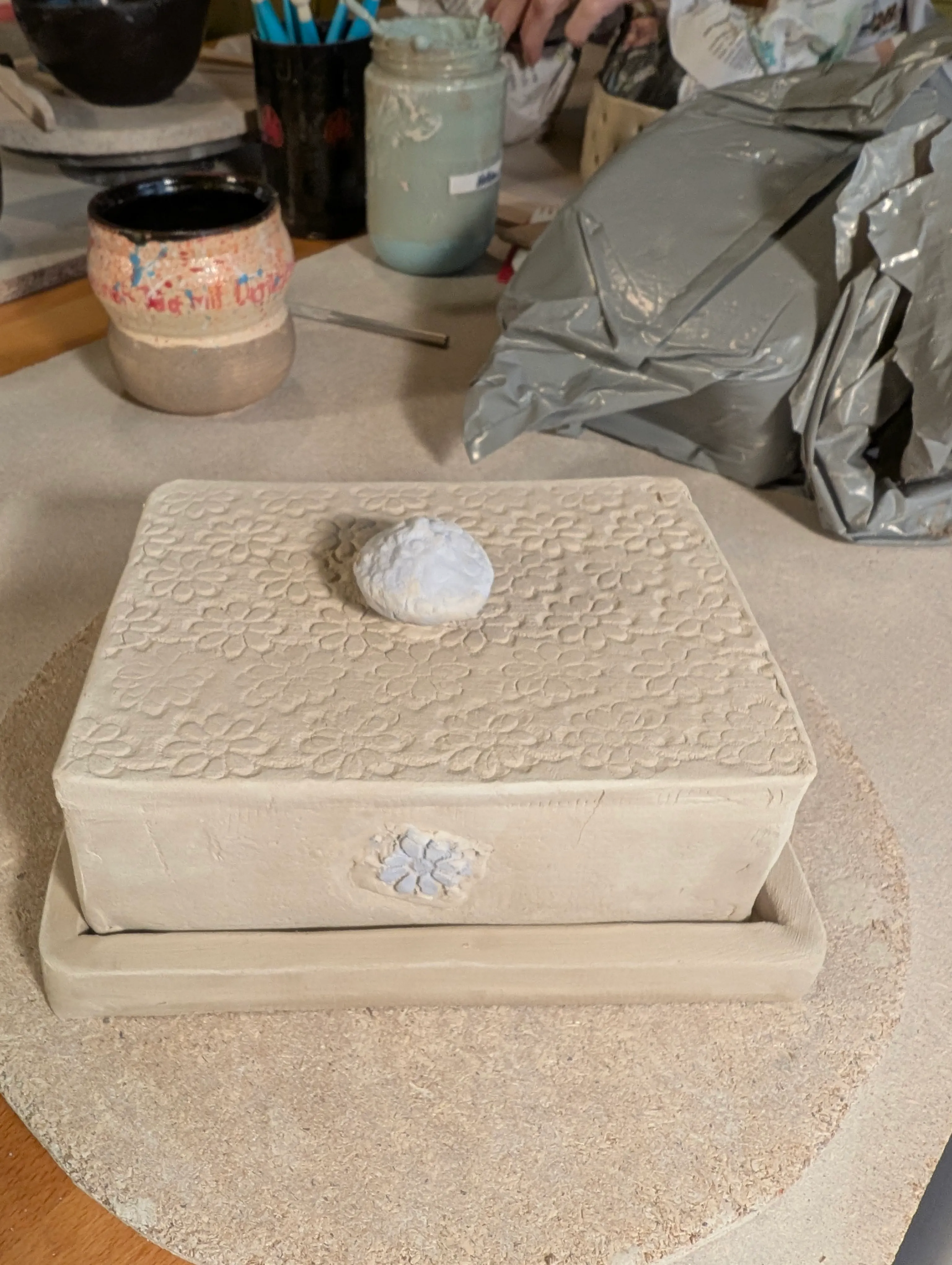 Geknetete Tonbox auf einem Arbeitstisch.