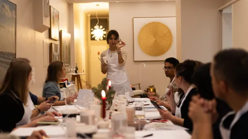 Instructor teaches painting class in bright room.