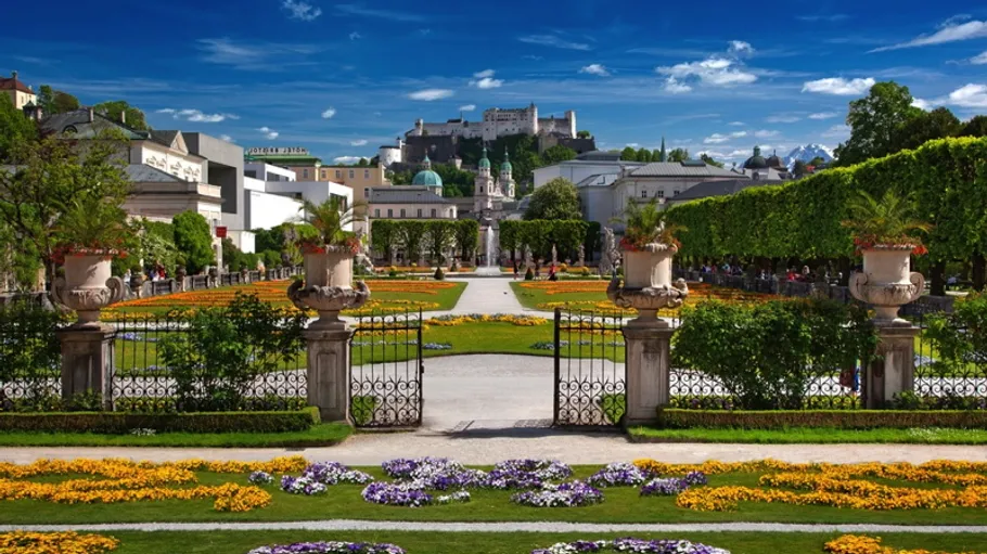 Prächtiger Garten mit Schloss im Hintergrund.