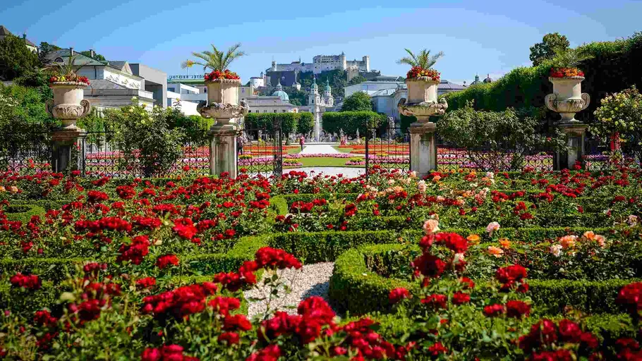 Bunter Garten mit Burg im Hintergrund.